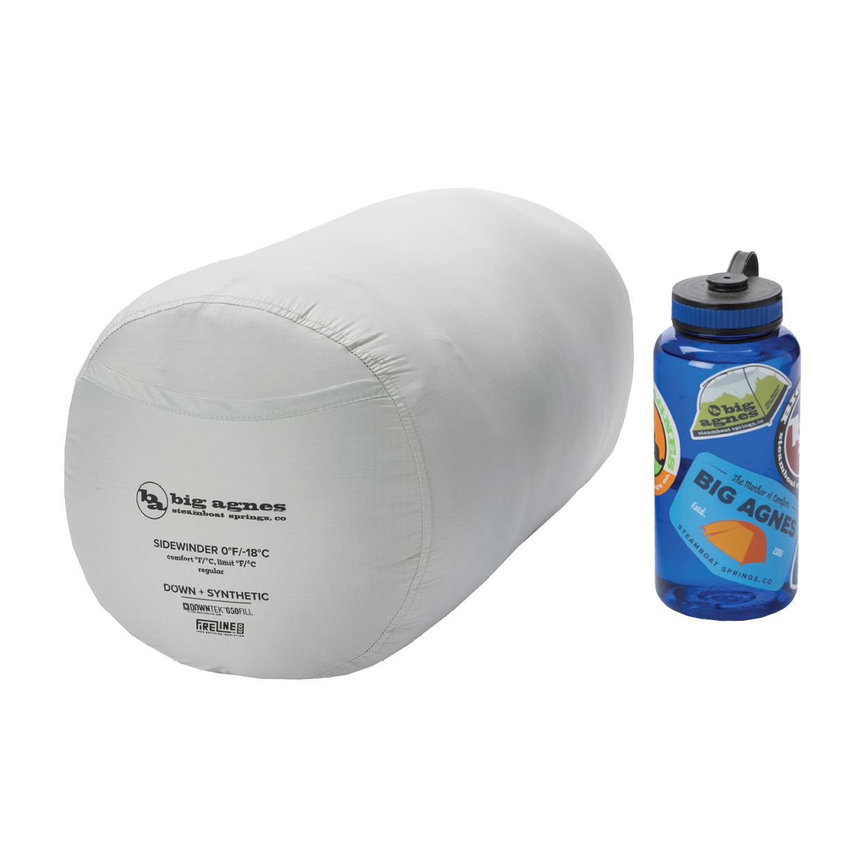 A light gray Big Agnes Returns Sidewinder 0˚ sleeping bag with body-mapped insulation, packed in a cylindrical stuff sack, sits next to a blue sticker-covered Nalgene bottle on a white background.