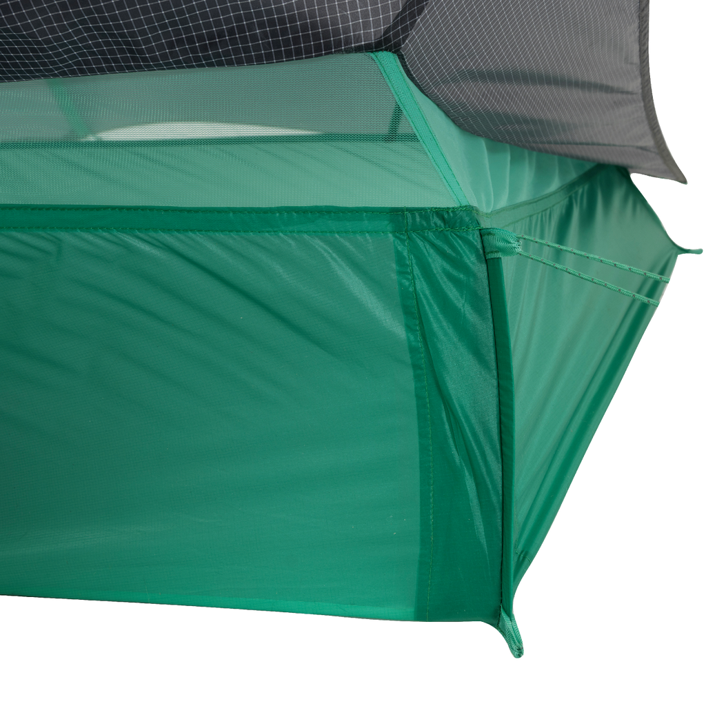 Close-up of the corner of the Big Agnes String Ridge VST 1.5 tent, an ultralight shelter featuring mesh upper panels, solid green lower fabric, and precise stitching that showcases its quality construction.